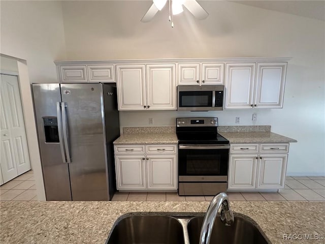 kitchen with sink, light tile patterned floors, white cabinets, and appliances with stainless steel finishes