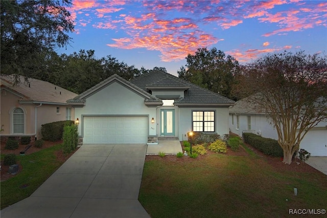 view of front facade with a yard and a garage