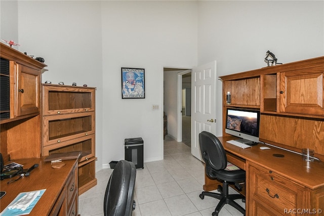 office area featuring a towering ceiling and light tile patterned flooring