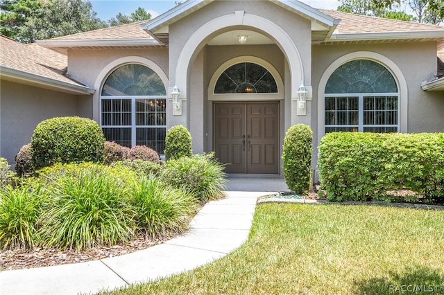 entrance to property with a lawn