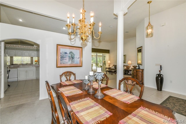 tiled dining space with decorative columns, high vaulted ceiling, and sink