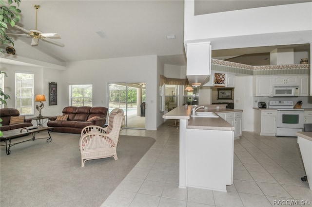 kitchen featuring white appliances, ceiling fan, light tile patterned floors, white cabinetry, and an island with sink