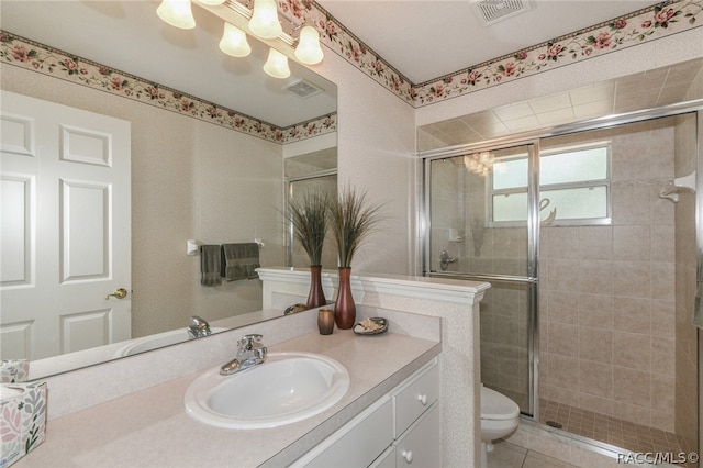 bathroom with tile patterned floors, vanity, toilet, and an enclosed shower