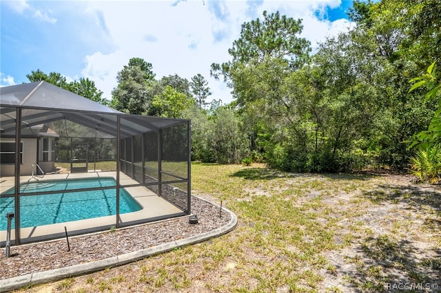 view of pool with glass enclosure and a lawn