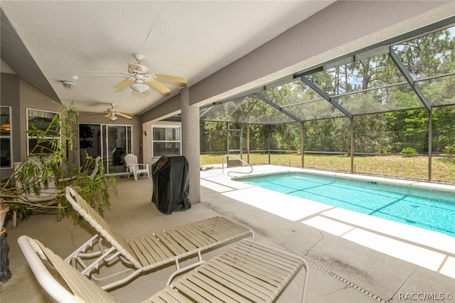 view of pool with a patio area, ceiling fan, and glass enclosure