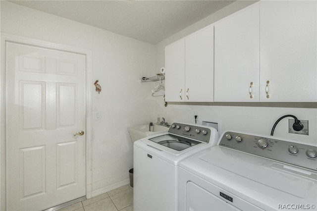 laundry room with washer and dryer, sink, light tile patterned floors, and cabinets