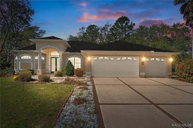 view of front of property featuring a garage and a lawn