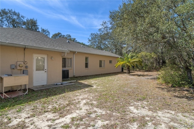 rear view of house featuring central AC unit