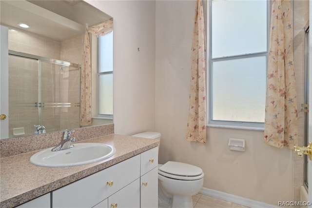 bathroom with tile patterned floors, vanity, toilet, and a shower with shower door