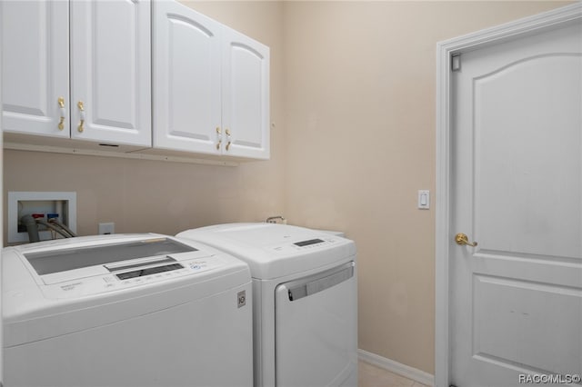 laundry room featuring separate washer and dryer and cabinets