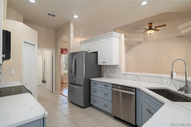 kitchen with light stone countertops, sink, white cabinets, and appliances with stainless steel finishes