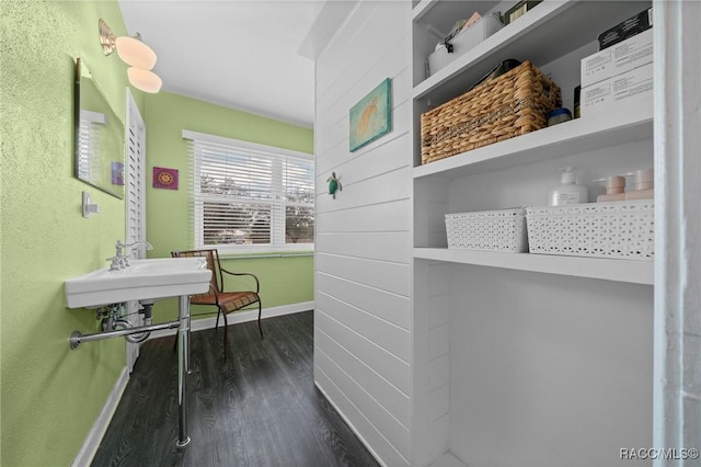 corridor with dark wood-type flooring and baseboards