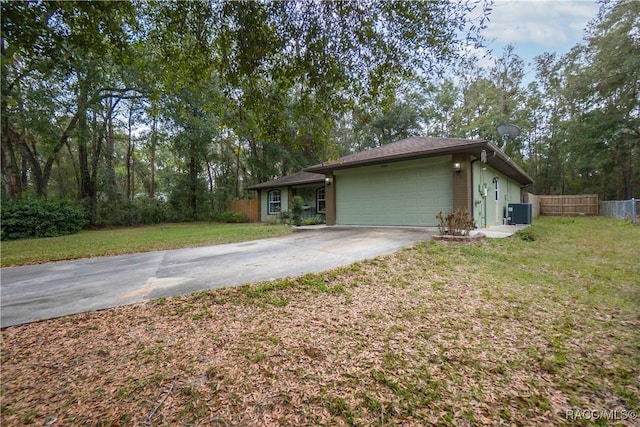 view of front facade with a front yard, cooling unit, and a garage