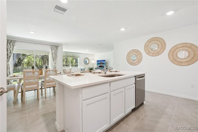 3342 W Crandon Dr, Dunnellon, FL 34433 - kitchen with a sink, dishwasher, light tile patterned floors, white cabinetry, and an island with sink