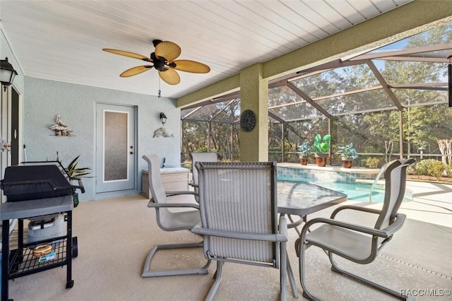 view of patio / terrace featuring pool water feature and glass enclosure