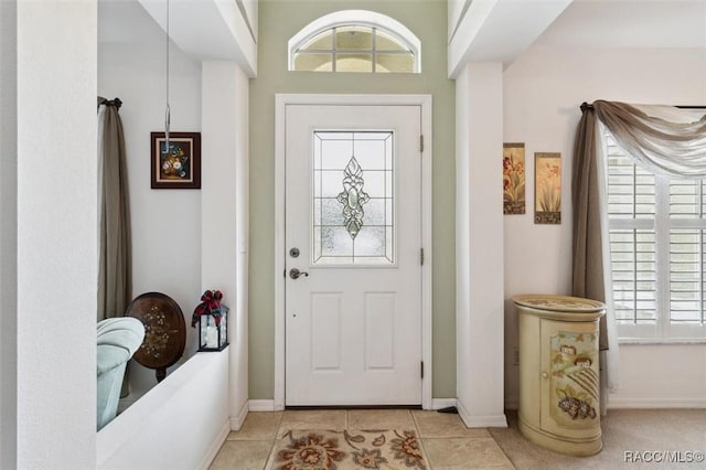 entrance foyer featuring light tile patterned floors and a wealth of natural light