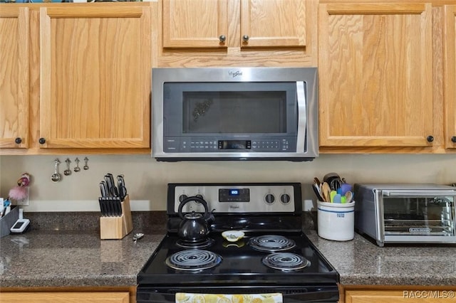 kitchen with light brown cabinets, black range with electric cooktop, and dark stone counters