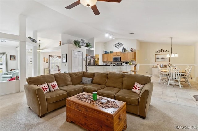 living room featuring ceiling fan with notable chandelier, lofted ceiling, and light carpet