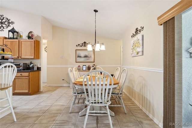 dining area featuring lofted ceiling, light tile patterned floors, and an inviting chandelier