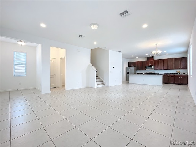 unfurnished living room with light tile patterned floors and an inviting chandelier