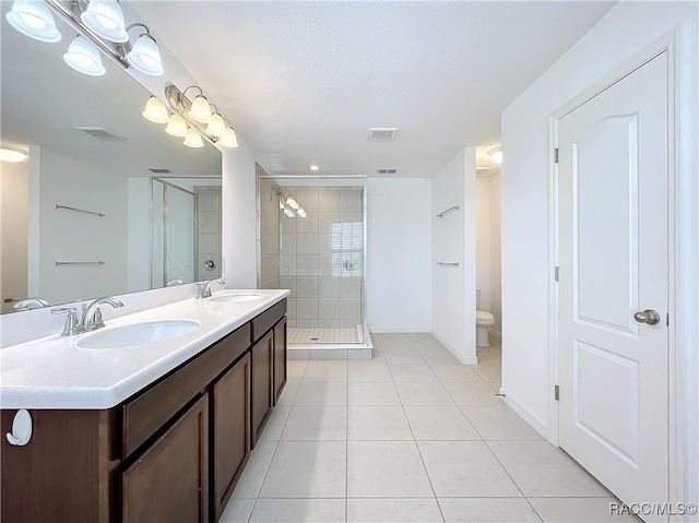 bathroom with walk in shower, tile patterned flooring, a textured ceiling, toilet, and vanity