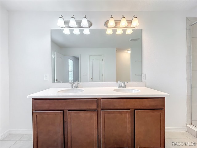 bathroom with a shower, vanity, and tile patterned floors