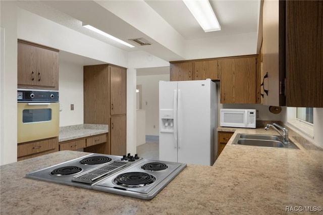 6580 E Glencoe St, Inverness, FL 34452 - kitchen with white appliances, a sink, light countertops, and brown cabinets