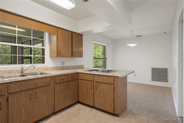 6580 E Glencoe St, Inverness, FL 34452 - kitchen with a sink, stovetop with downdraft, a peninsula, light countertops, and pendant lighting