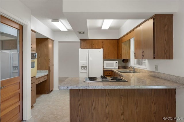 6580 E Glencoe St, Inverness, FL 34452 - kitchen with white appliances, a sink, a peninsula, light countertops, and brown cabinetry