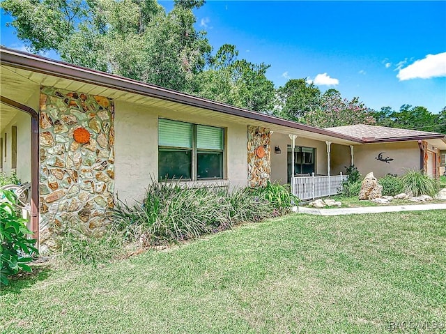 2582 W Fairway Loop, Citrus Springs, FL 34434 - view of front of home with a front yard, stucco siding, stone siding, and covered porch