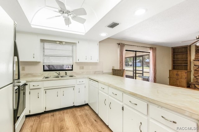 kitchen featuring white cabinets, sink, light hardwood / wood-style floors, kitchen peninsula, and stainless steel appliances