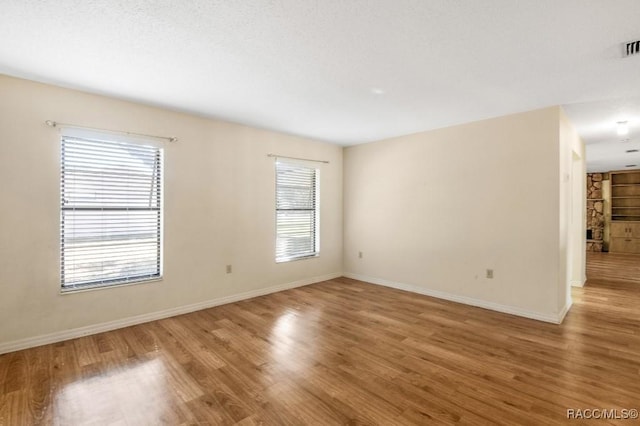 unfurnished room featuring hardwood / wood-style flooring and plenty of natural light