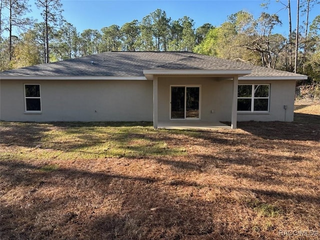 back of house with a lawn and a patio area