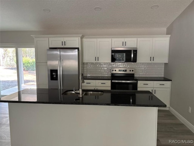 kitchen featuring tasteful backsplash, white cabinetry, and stainless steel appliances