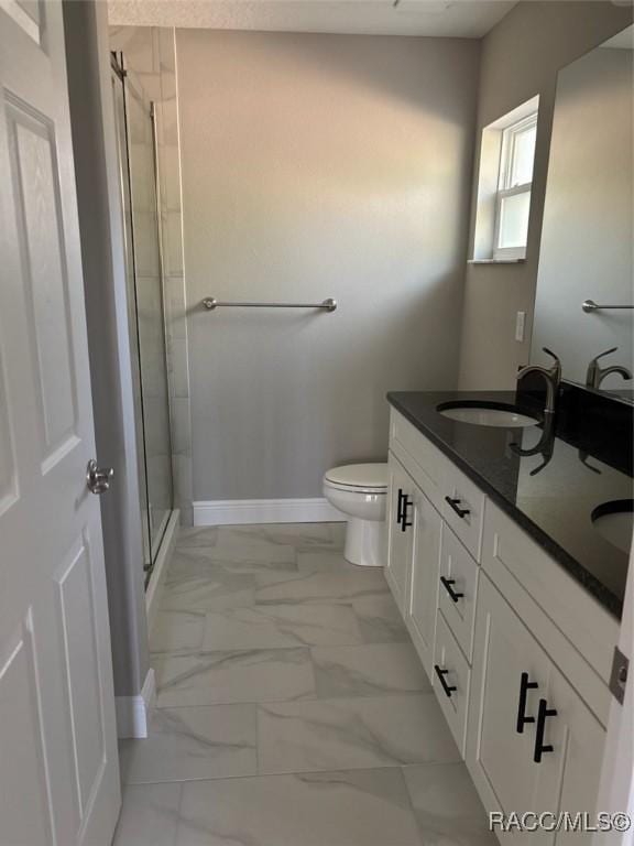 bathroom featuring baseboards, a stall shower, a sink, toilet, and marble finish floor