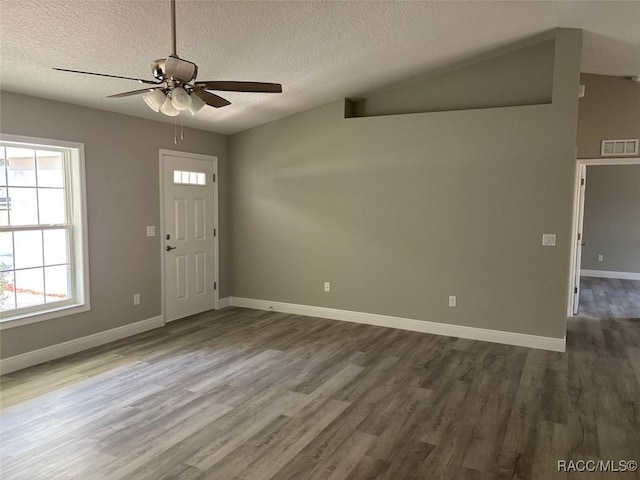 entrance foyer with visible vents, vaulted ceiling, wood finished floors, a textured ceiling, and a ceiling fan