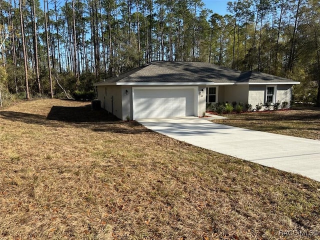 view of front of home with stucco siding, a front lawn, concrete driveway, and an attached garage