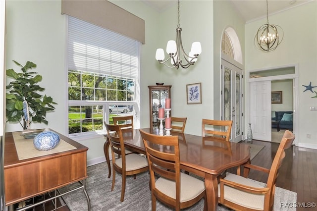 dining space with ornamental molding, a notable chandelier, dark hardwood / wood-style flooring, and french doors