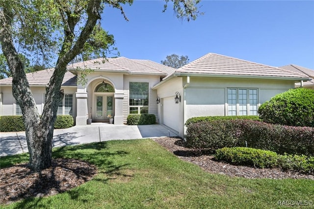 ranch-style house featuring french doors, a garage, and a front yard