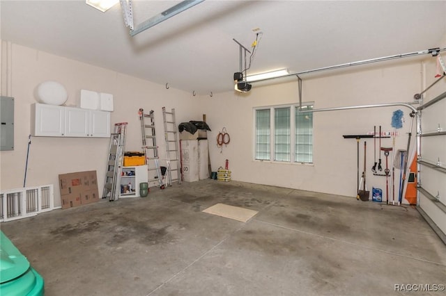 garage with a garage door opener and electric panel