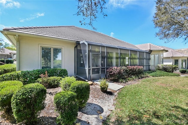 back of house with a yard and a sunroom