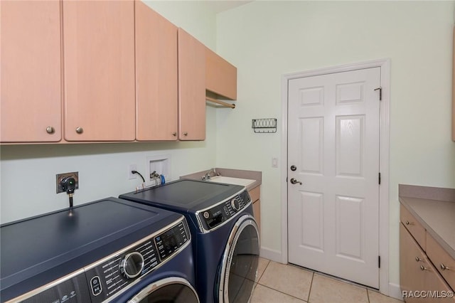 laundry room featuring light tile patterned floors, sink, cabinets, and washer and dryer