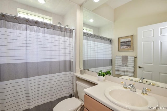 bathroom featuring a shower with curtain, vanity, and toilet