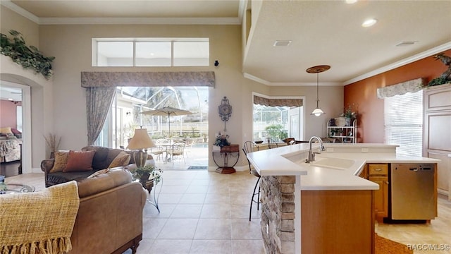 kitchen with ornamental molding, a sink, stainless steel dishwasher, and light tile patterned floors