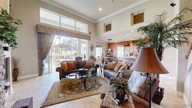 living area with baseboards, a high ceiling, crown molding, a fireplace, and light tile patterned flooring