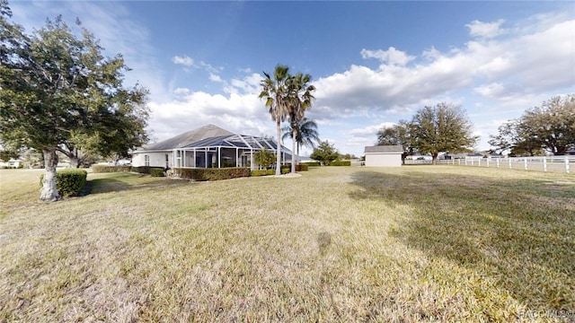 view of front facade with a lanai, fence, and a front lawn