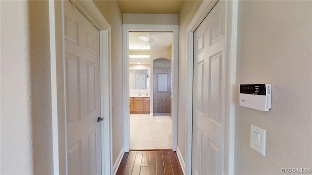 hall with dark wood-type flooring and baseboards