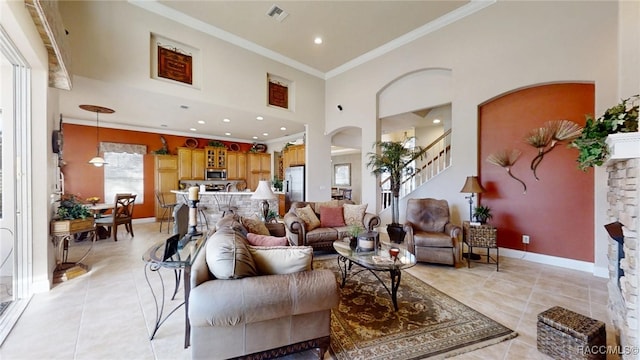 living room featuring crown molding, visible vents, light tile patterned flooring, baseboards, and stairs