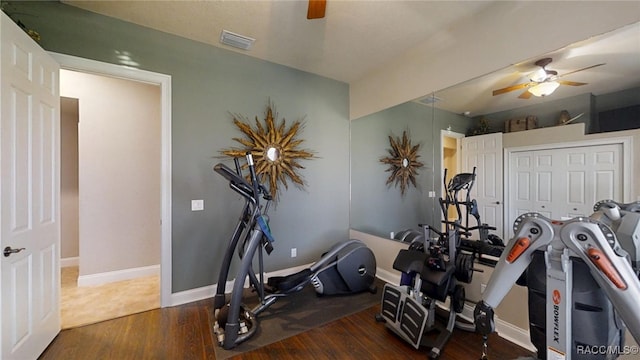 exercise room featuring visible vents, wood finished floors, a ceiling fan, and baseboards