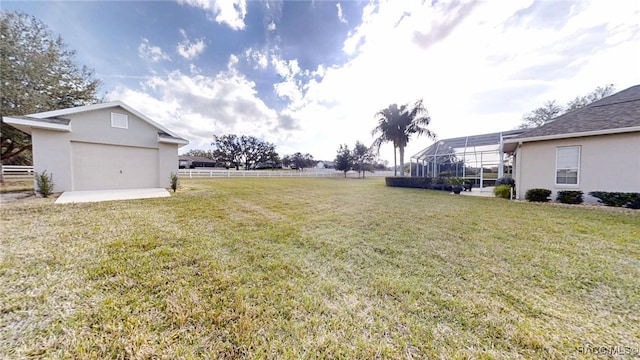 view of yard with glass enclosure and fence